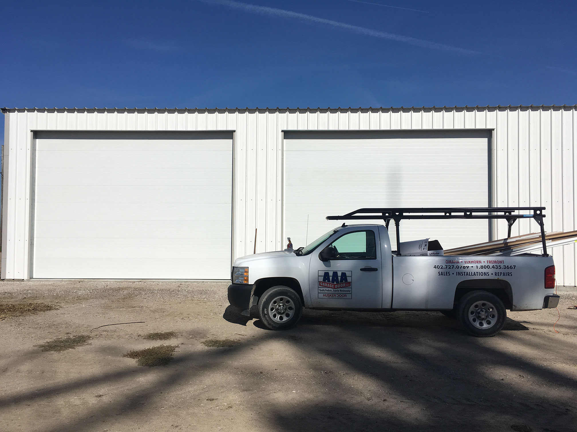 a AAA Garage Door truck parked outside a Omaha business after installing two new overhead door
