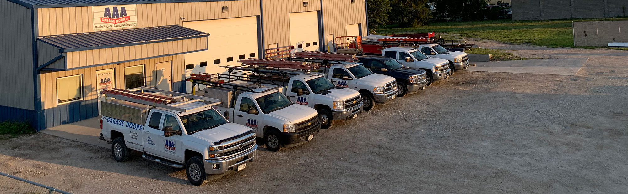 7 trucks lined up outside of AAA Garage Door's office in Fremont Nebraska