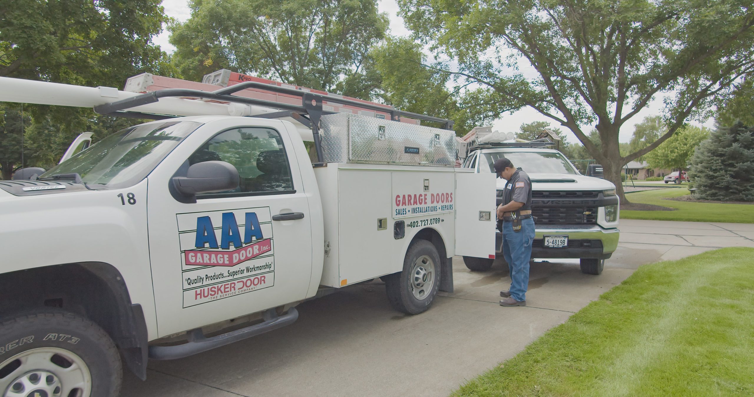 2 AAA Garage Door service trucks showing up at a customer's house to provide garage services
