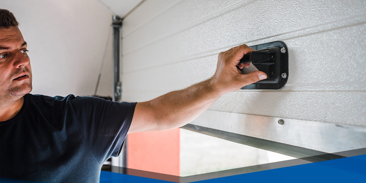 a man is fixing a roll-up garage door