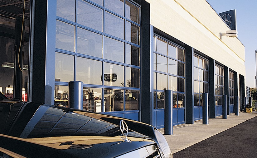 a mercedes dealership with multiple blue garage doors