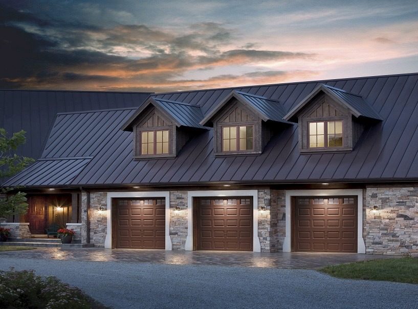 a house with three garage doors and a metal roof